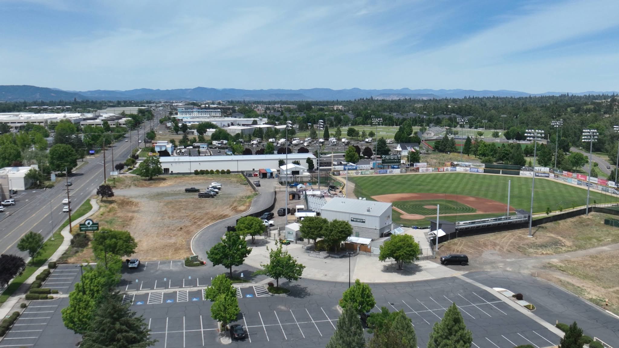 Wide aerial view of the Harry & David Field ballpark complex and parking areas in Medford, Oregon.