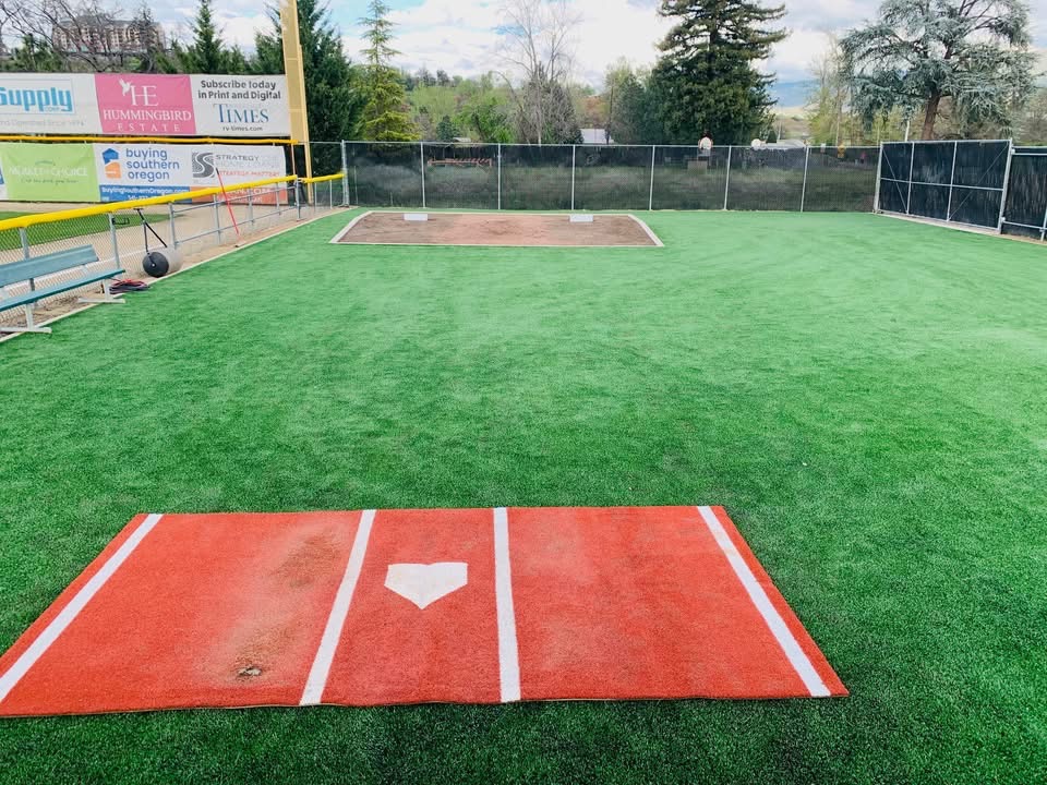 Bullpen and warm-up area at Harry & David Field in Medford, Oregon &mdash; turf practice mound and home plate mat used by the Medford Mustangs and visiting American Legion teams.